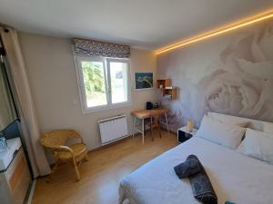 a bedroom with a bed and a window and a desk at Chambre d'Hôtes Valérie in Penvénan