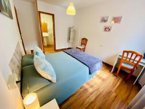 a bedroom with a blue bed and a chair at Benvinguts a Casa Nostra in El Pont de Suert
