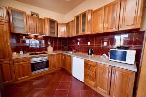 a kitchen with wooden cabinets and a white microwave at Penthouse S in Bar +4 photos