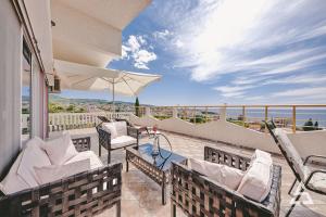 a balcony with chairs and a table and an umbrella at Penthouse S in Bar