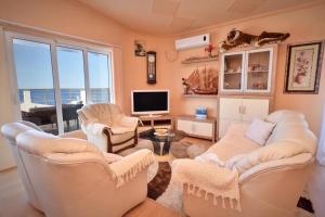 a living room with a couch and chairs and a television at Penthouse S in Bar