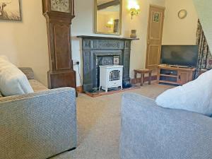 a living room with a fireplace and a television at Bradley House in Harrop Fold