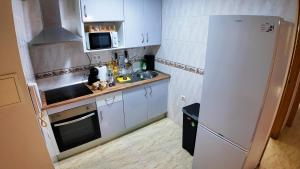 a small kitchen with a white refrigerator and a sink at Ruralux Sierra Quesada in Quesada