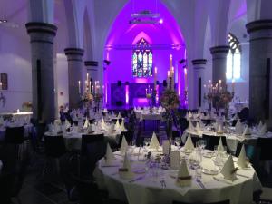 a banquet hall with white tables and purple lighting at Kloster Heidberg in Eupen
