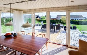 a dining room with a wooden table and a patio at Awesome Home In Haderslev With Wifi in Haderslev
