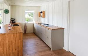 a kitchen with white cabinets and a wooden floor at Awesome Home In Haderslev With Wifi in Haderslev +20 photos