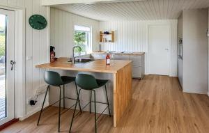 a kitchen with a sink and a counter with stools at Awesome Home In Haderslev With Wifi in Haderslev