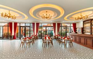 a dining room with tables and chairs and chandeliers at The Jam Central in Luang Prabang