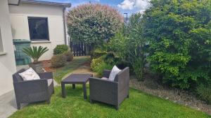 a patio with two chairs and a table in a yard at Studio La passagère in Plouvorn