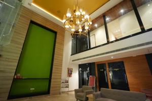 a living room with a green wall and a chandelier at Celebrant Hotel in Varanasi
