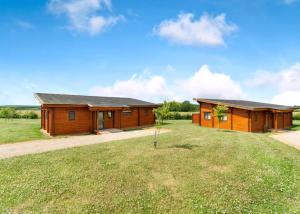 a log cabin with a grassy yard in front of it at Fairview Lodges in Hollym