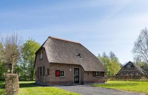 an old brick barn with a gambrel roof at Bungalowpark Hoge Hexel in Hoge-Hexel
