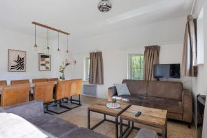 a living room with a couch and a table at Bungalowpark Hoge Hexel in Hoge-Hexel