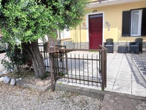 a fence in front of a house with a red door at Sleep & Fly Studio Smart in Case Nuove