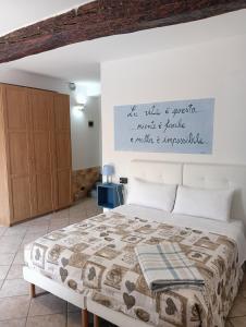 a bedroom with a large bed with a sign on the wall at Sleep & Fly Studio Smart in Case Nuove +4 photos
