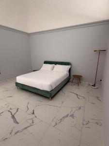 a bedroom with a bed and a marble floor at Vulcano Rooms 1 in Catania