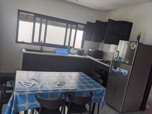 a kitchen with a table and a refrigerator at Ambourvi in Mahajanga