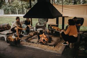a group of people sitting around a fire at Pousada Recanto das Cerejeiras in Rio Grande
