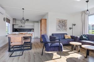 a living room with a couch and a table at Bungalowpark Hoge Hexel in Hoge-Hexel