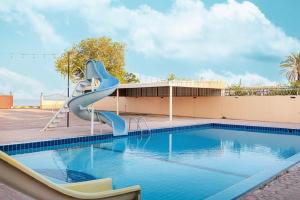 a swimming pool with a slide next to a building at Best chalet 4 BHK for group gatherings with beach access and private pool in Fujairah +51 photos