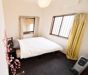 a small bedroom with a bed and a window at 姫路駅から徒歩4分 最大13名に貸し切り一軒家 先姫亭 in Himeji
