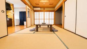 a living room with a table on a rug at 姫路駅から徒歩4分 最大13名に貸し切り一軒家 先姫亭 in Himeji
