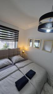 a bedroom with a bed with two blue pillows on it at Prestige Slow Lake Centrum Jezioro Magistrackie 100m Internet in Mrągowo