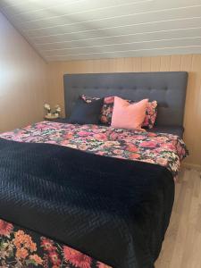 a bedroom with a large bed with colorful pillows at Sjåen Panorama in Kragerø