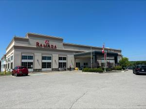 a karma store with a car parked in a parking lot at Ramada by Wyndham Trenton in Trenton