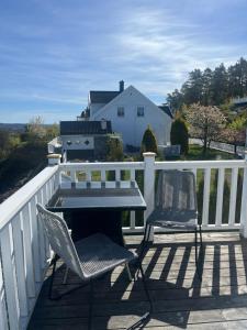 a patio with two chairs and a table on a deck at Sjåen Panorama in Kragerø
