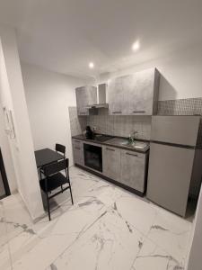 a kitchen with a sink and a refrigerator and a table at Vulcano Rooms 1 in Catania