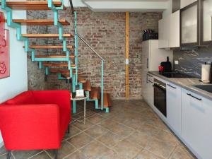 a living room with a red chair and a brick wall at Ferienhaus Zur alten Korbmacherei in Freyburg