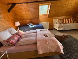 a bedroom with two beds and a crib at Chalupa V soukromí - Chřibská in Chřibská
