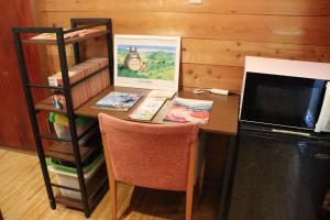 a desk with a microwave and a table with a computer at Yamagata Zao Pension Apron Stage in Kaminoyama