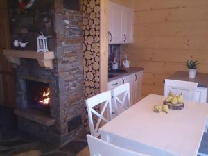 a kitchen with a table and a brick fireplace at Całoroczne domki Pasja II View,Lake & Ski in Kluszkowce