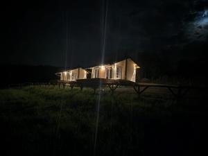 ein nachts beleuchtetes Haus auf einem Feld in der Unterkunft krupajsko vrelo in Milanovac