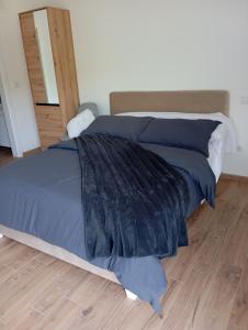ein Bett mit einer blauen Bettdecke in einem Schlafzimmer in der Unterkunft krupajsko vrelo in Milanovac
