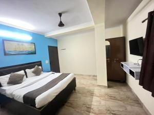 a bedroom with a large bed with blue walls at Hotel South embassy near Durgabai dekhmukh metro in New Delhi