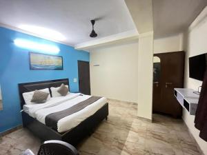 a bedroom with a bed and a blue wall at Hotel South embassy near Durgabai dekhmukh metro in New Delhi +8 photos