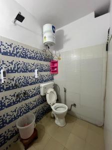 a bathroom with a toilet and a bucket in it at Hotel South embassy near Durgabai dekhmukh metro in New Delhi