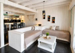 a living room with two beds and a table at As Palhas in Icaraí