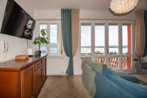 a living room with a couch and some windows at Casa di Emilia Iseo in Predore