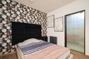 a bedroom with a bed and a wall with flowers at Apartament Gold 3 in Złotoryja