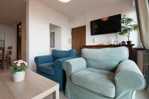 a living room with two blue chairs and a table at Casa di Emilia Iseo in Predore