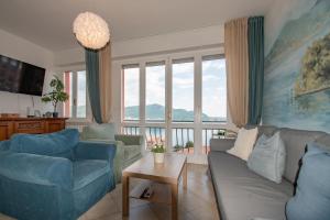 a living room with a couch and chairs and windows at Casa di Emilia Iseo in Predore
