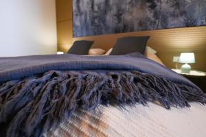 a bedroom with a bed with a blue blanket on it at Casa di Emilia Iseo in Predore +19 photos