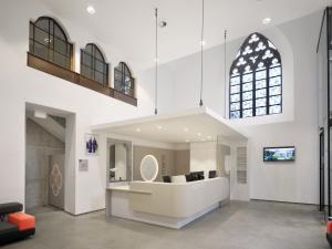 a living room with a large white room with a window at Kloster Heidberg in Eupen