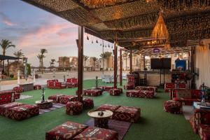 a group of chairs and tables on a green field at Seagull Beach Resort - Families and Couples Only in Hurghada