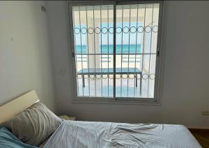 a bedroom with a window with a view of the ocean at Villa Sounine Rafraf in Bizerte