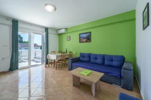 a living room with a blue couch and a table at Apartments Anka in Krk